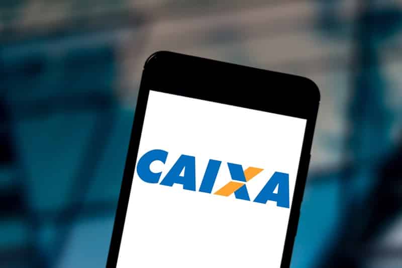 Imagem contendo um celular com a logo da CAIXA