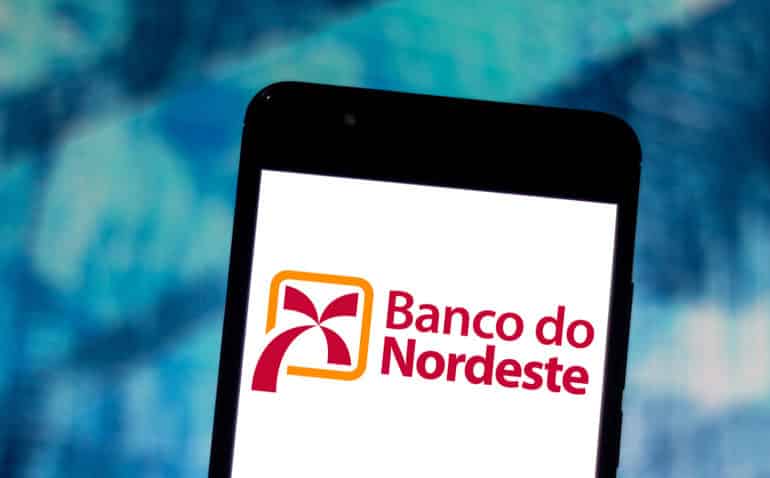 Imagem com celular contendo o logo do Banco do Nordeste